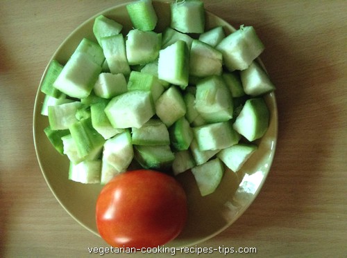 Peeled and chopped ridge gourd and a tomato